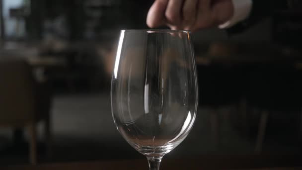 Cantinero vierte vino tinto en un vaso de gran recipiente transparente
 - Metraje, vídeo
