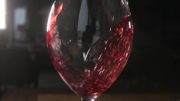 Barman nalewa czerwonego wina w szkle z duży przezroczysty pojemnik - Materiał filmowy, wideo