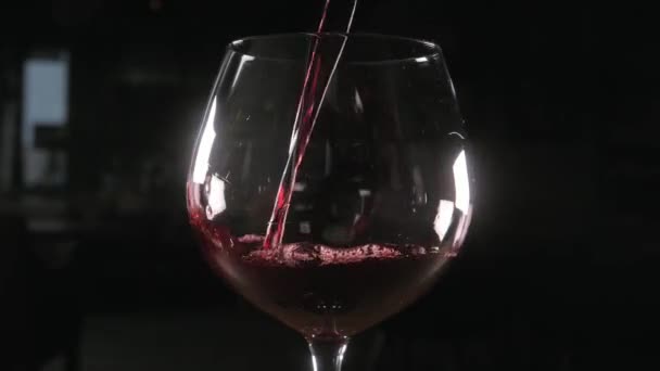Barman nalévá červené víno ve skle z velké průhledné nádoby - Záběry, video