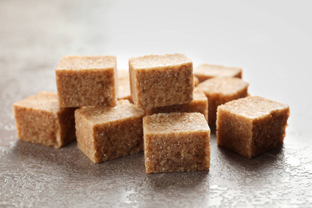 Cubes of brown sugar on table - Fotó, kép