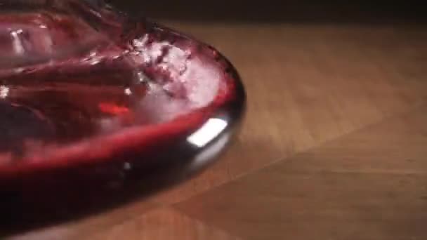 Κόκκινο κρασί χύνεται σε καράφα στο φόντο εστιατόριο. αναμιγνύει με οξυγόνο - Πλάνα, βίντεο