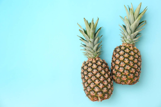 Fresh pineapples on color background - Fotografie, Obrázek