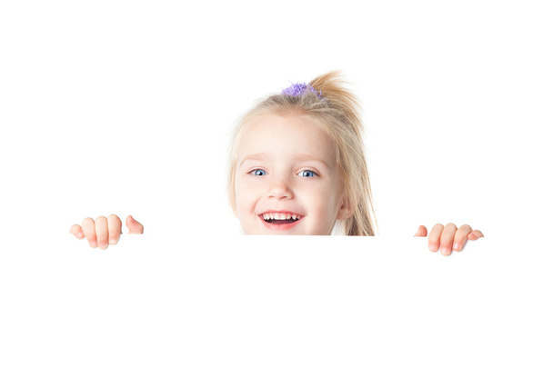 Happy little girl looking over empty board - Foto, Imagen