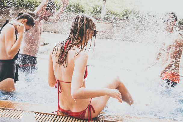 Группа друзей наслаждается отдыхом в летнее время. Молодые люди веселятся в бассейне
  - Фото, изображение