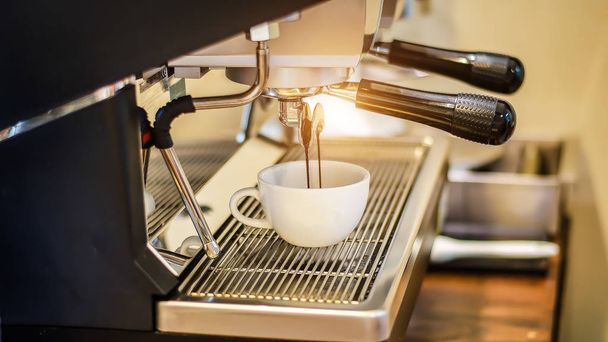 Café fluyendo en una taza de la máquina de café expreso
 - Foto, Imagen