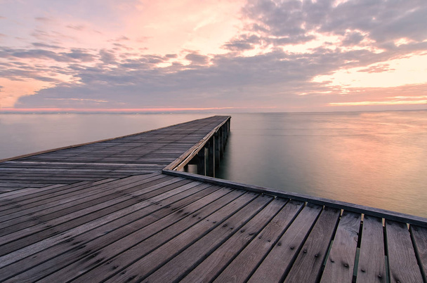 Puente de madera en el mar al atardecer
 - Foto, imagen