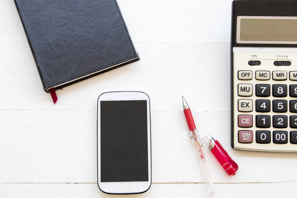 planificador portátil con teléfono móvil y calculadora para negocios en el escritorio de la oficina
 - Foto, imagen