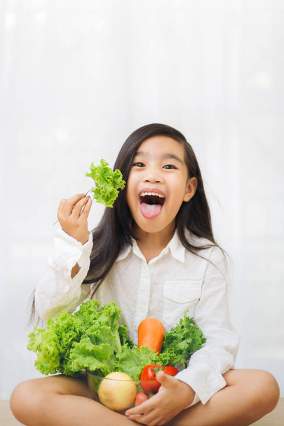 Aasialainen söpö tyttö syö tuoretta salaattia, terveellistä ruokavaliota käsite
 - Valokuva, kuva