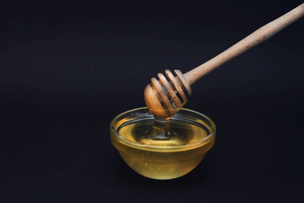 Honey in Glass bowl with dipper over dark Background Isolated with copy space. - Foto, immagini