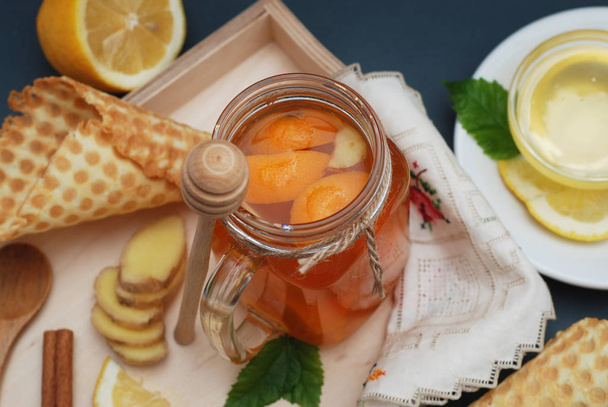 Ginger or Fruit Citrus Tea. tea. Ginger, lemon, mint leaves and Honney. Waffle cones. Selective focus. Dark Background. - Фото, изображение