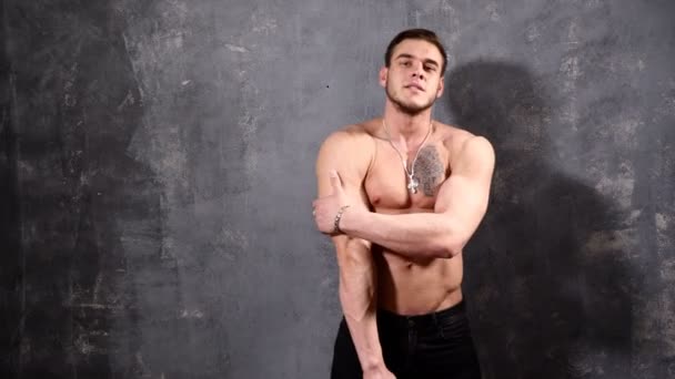 kräftiger und muskulöser Bodybuilder, der posiert und seine Weste aufreißt. perfekte Sixpack Bauchmuskeln eines muskulösen jungen Mannes - Filmmaterial, Video