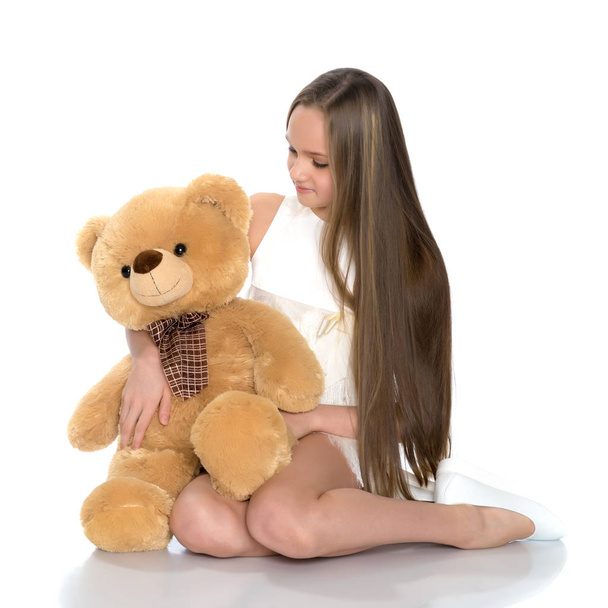 A teenage girl with a teddy bear. - 写真・画像