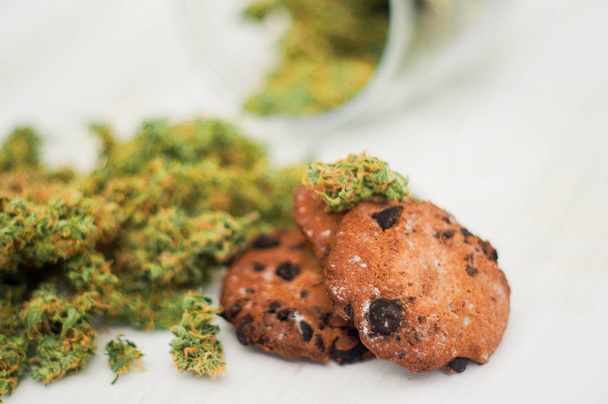 Cookies with cannabis and buds of marijuana on the table. Concept of cooking with cannabis herb. Treatment of medical marijuana for food use - Photo, Image