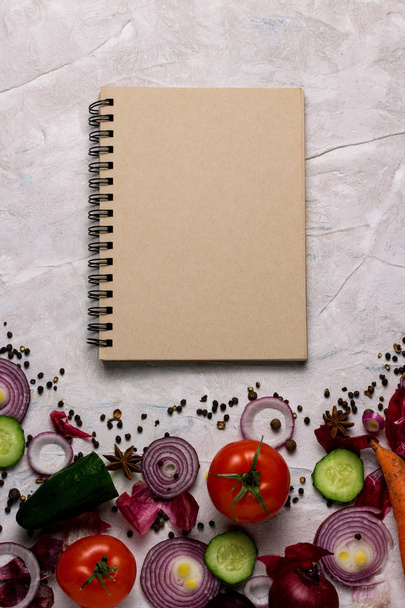 Φρέσκα λαχανικά και σημειωματάριο για τις συνταγές τροφίμων για το φως Backg - Φωτογραφία, εικόνα