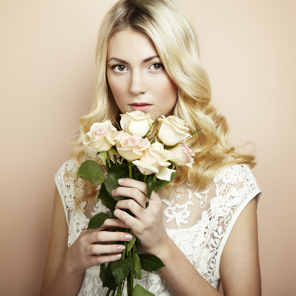 Portrait of a beautiful blonde woman with flowers - Фото, изображение