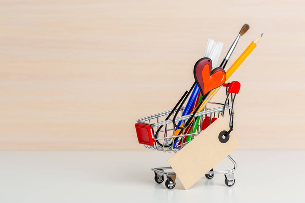 Stationery items in shopping trolley at left side - Foto, Bild