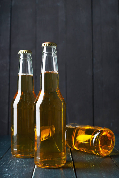 Beer in bottles on wooden table - Foto, afbeelding
