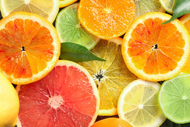 Slices of ripe citrus fruits as background - Photo, image
