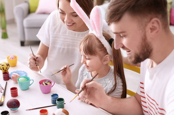Family painting Easter eggs together at table - Foto, immagini
