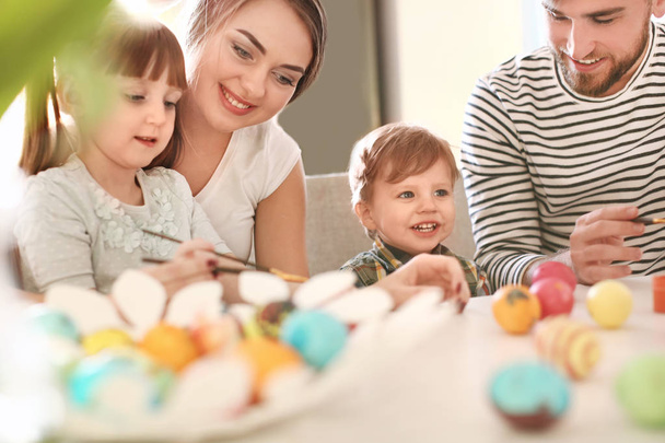 Family painting Easter eggs together at table - Foto, Imagen