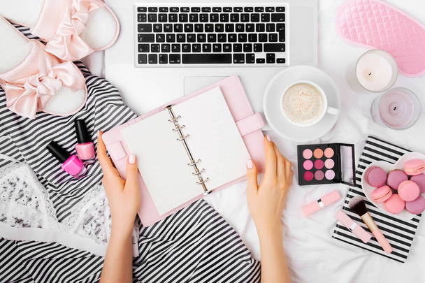 Fashion blogger working with laptop and planner in bed and drinking coffee. - Fotoğraf, Görsel