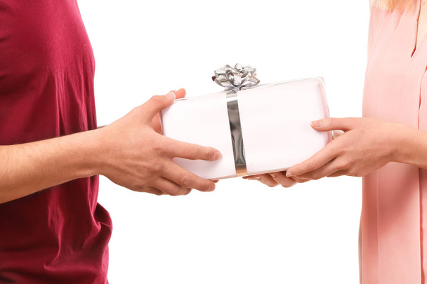 Hands of young loving couple holding gift box on white background - 写真・画像