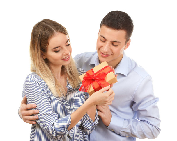 Happy young couple with gift box on white background - Photo, Image