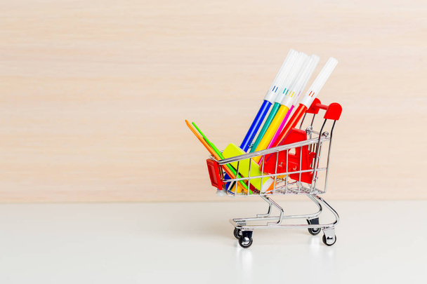 Stationery items in shopping trolley at left side - Photo, Image
