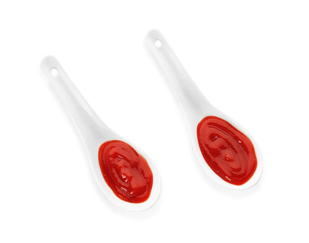 Κουτάλια με κόκκινη σάλτσα σε λευκό φόντο - Φωτογραφία, εικόνα