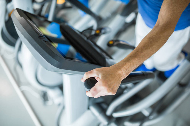 Man standing on stair stepper at gym - Photo, Image