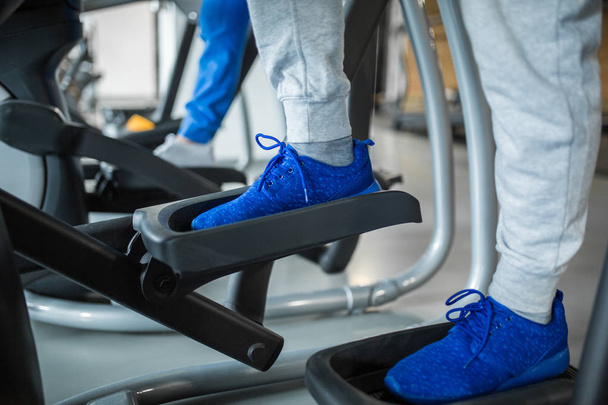 Man legs standing on stair stepper at gym - Photo, Image