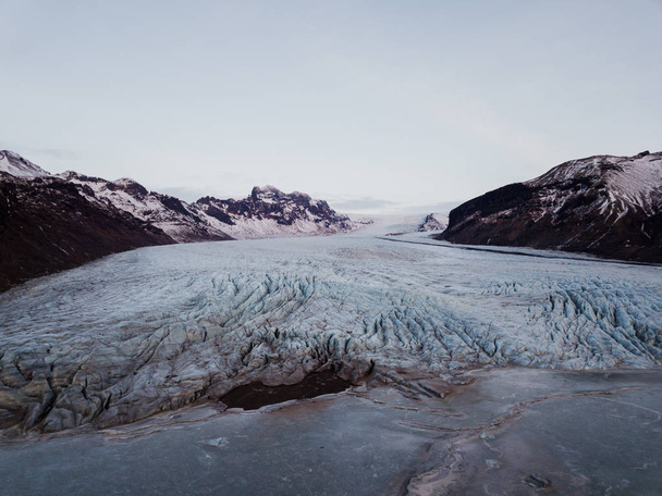 A glacier in Iceland with a frozen lake in front of it, shot with a drone - Photo, Image