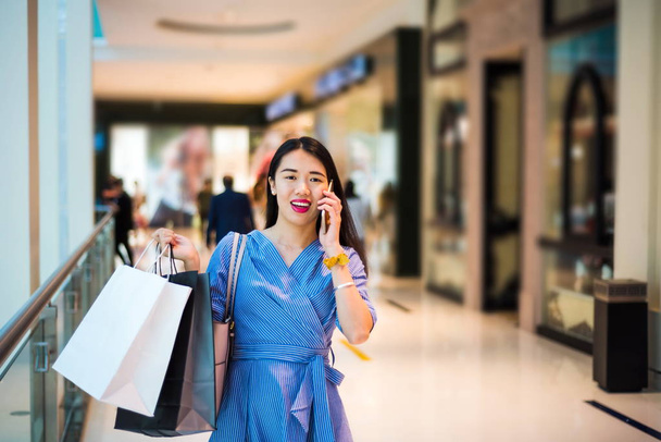 Girl using phone while doing shopping - Photo, Image