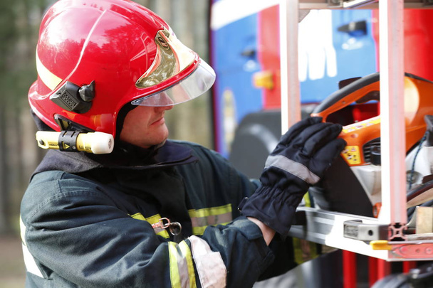 Białoruś, Gomel miasta. Przeciwpożarowe 06.04.2017.Firefighter lasu pobiera węże pożarowe. Dzielny strażak. Praca strażaka - Zdjęcie, obraz