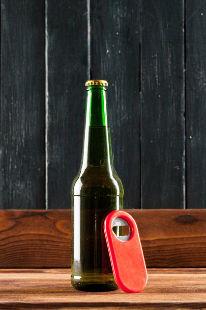 Bottle of beer on wooden table - Фото, изображение