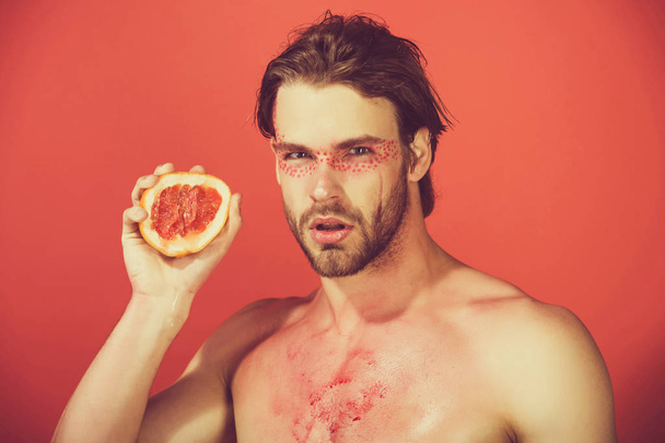 handsome man with creative fashionable makeup hold grapefruit, v - Fotó, kép