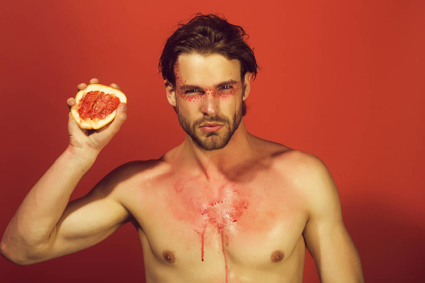grapefruit in hand ofman with creative fashionable makeup, vitam - Фото, изображение