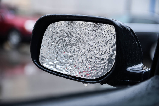 Vehicle mirror covered in ice during freezing rain - 写真・画像