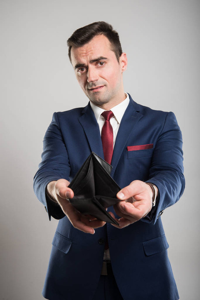 Attractive business man showing empty wallet - Foto, imagen