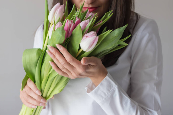 Spring bouquet of pink tulips in woman's hands - Zdjęcie, obraz