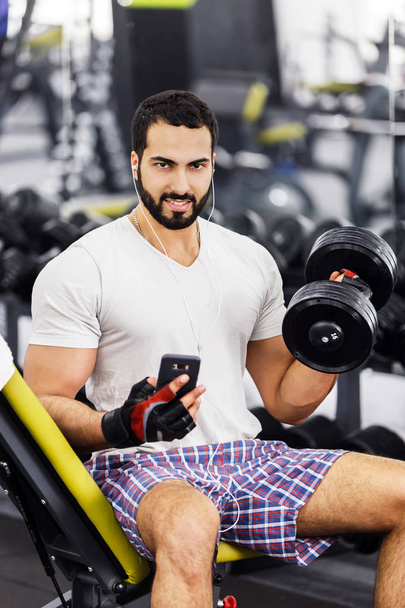 Man with Phone and Dumbell - Foto, Bild