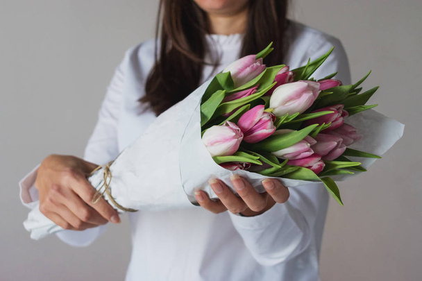 Spring bouquet of pink tulips in woman's hands - Foto, imagen