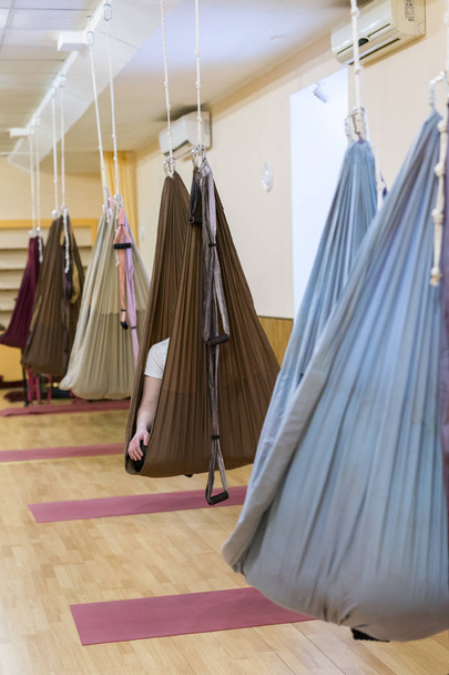 The hall for the practice of fly yoga. People sit in hammocks - Photo, Image