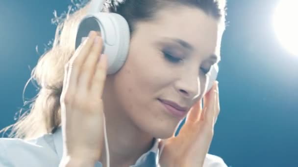 Woman dancing and listening to music, she is wearing headphones and having fun - Materiaali, video