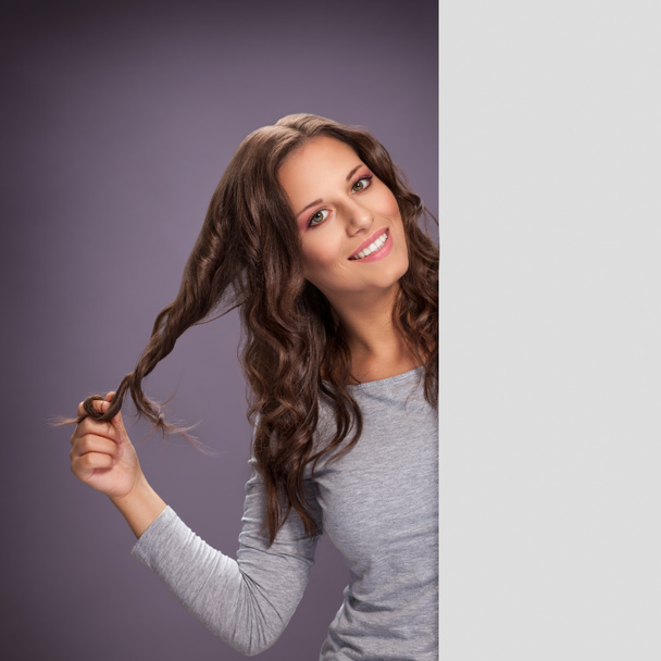 Jeune brune frisant ses cheveux avec le doigt
 - Photo, image