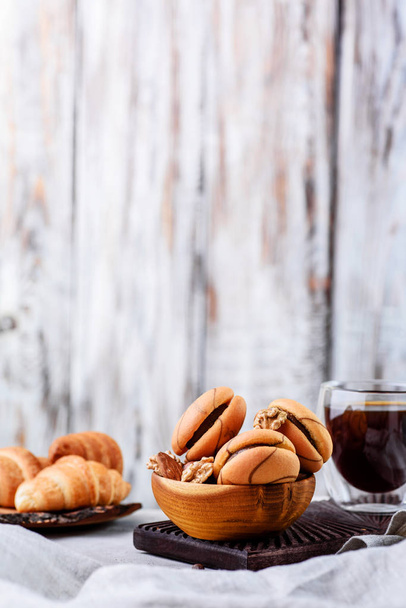 cookies in wooden plates with coffee on a light background - Photo, Image