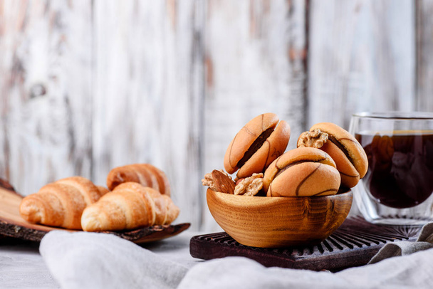 Kekse in Holztellern mit Kaffee auf hellem Hintergrund - Foto, Bild