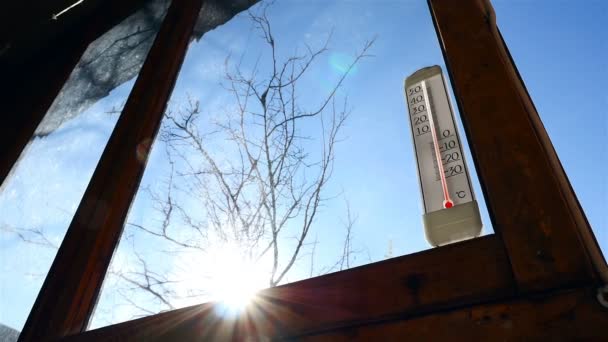 Thermometer am Fenster im Hintergrund der Sonne. schöne Sonnenblende. Temperatur über Null - Filmmaterial, Video