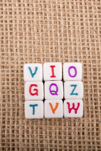 Cubos de letra alfabeto colorido em uma tela de linho
 - Foto, Imagem