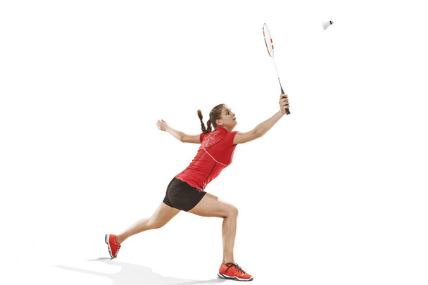 Young woman playing badminton over white background - Foto, Imagem